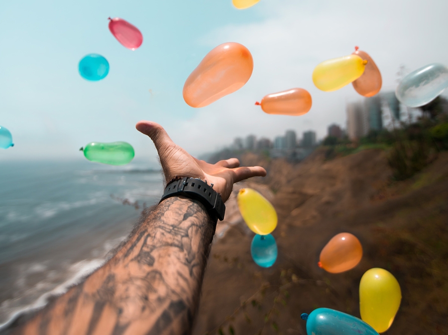 Multi-coloured balloons being thrown up in the air