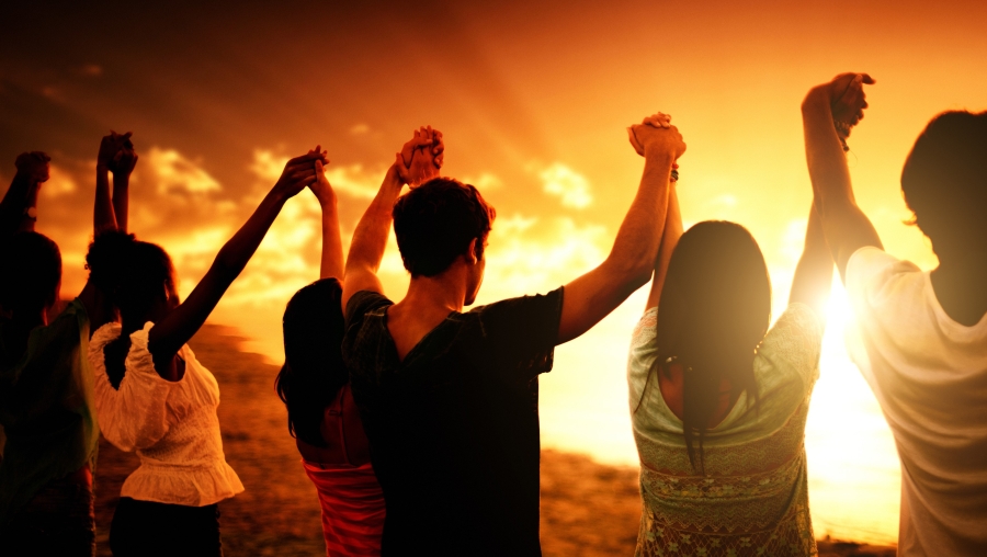 Group of people raising hands together