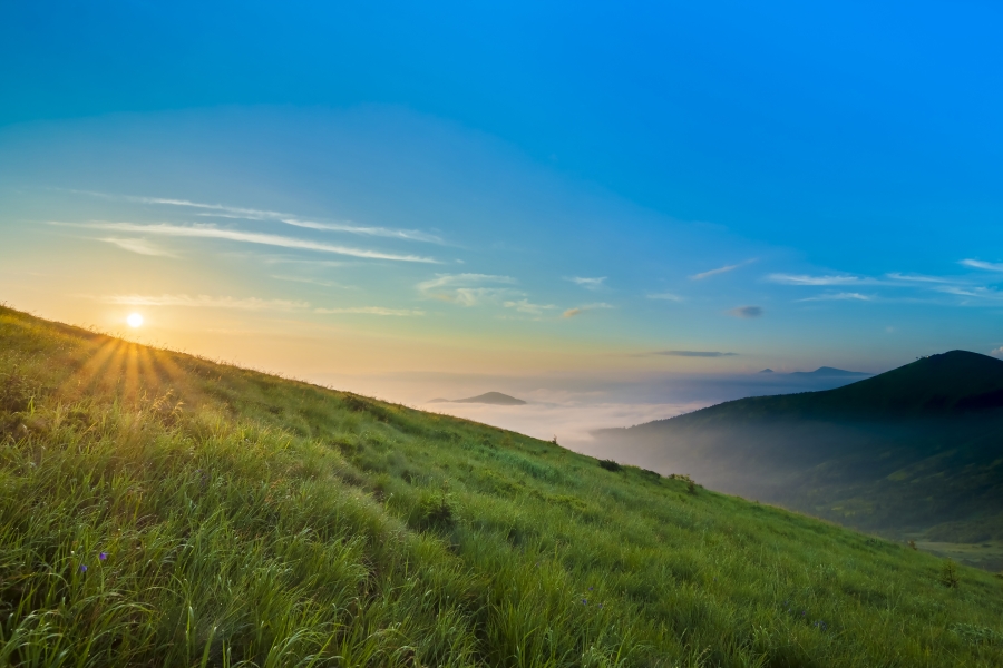 Hill with sun rising in distance